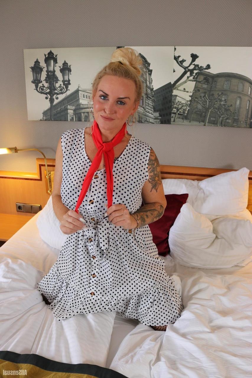 12P Tattooed blonde Frida looses one of her large breasts from a black brassiere