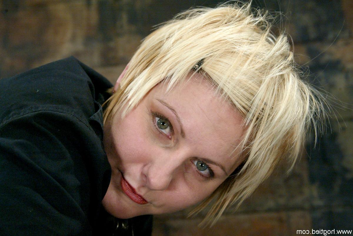 20P Die schöne blonde Vendetta lässt sich in einem Metall-Bondage ihre rasierte Fotze fingern