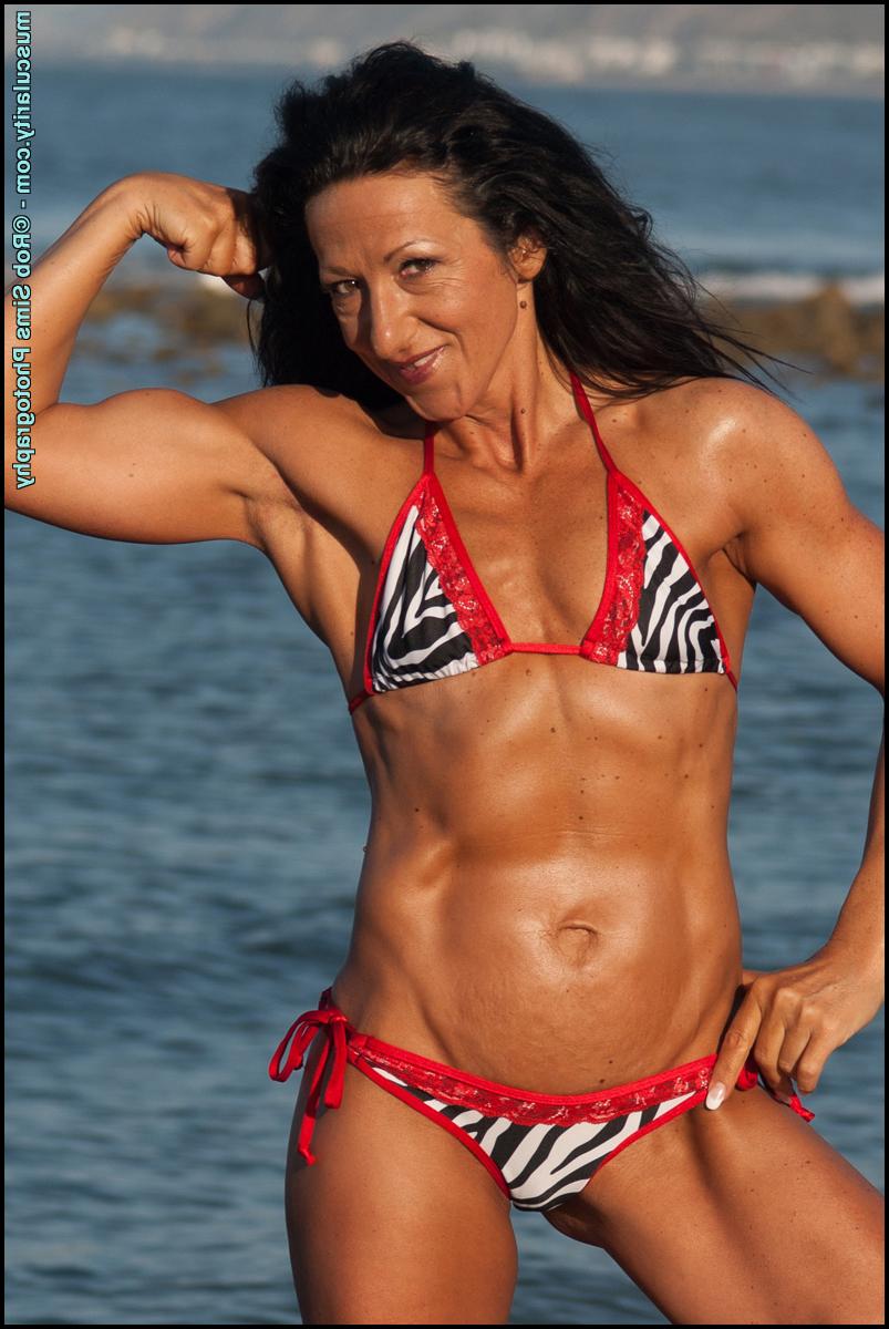 15P Brunette bodybuilder Kim Haynes models a bikini while at the beach