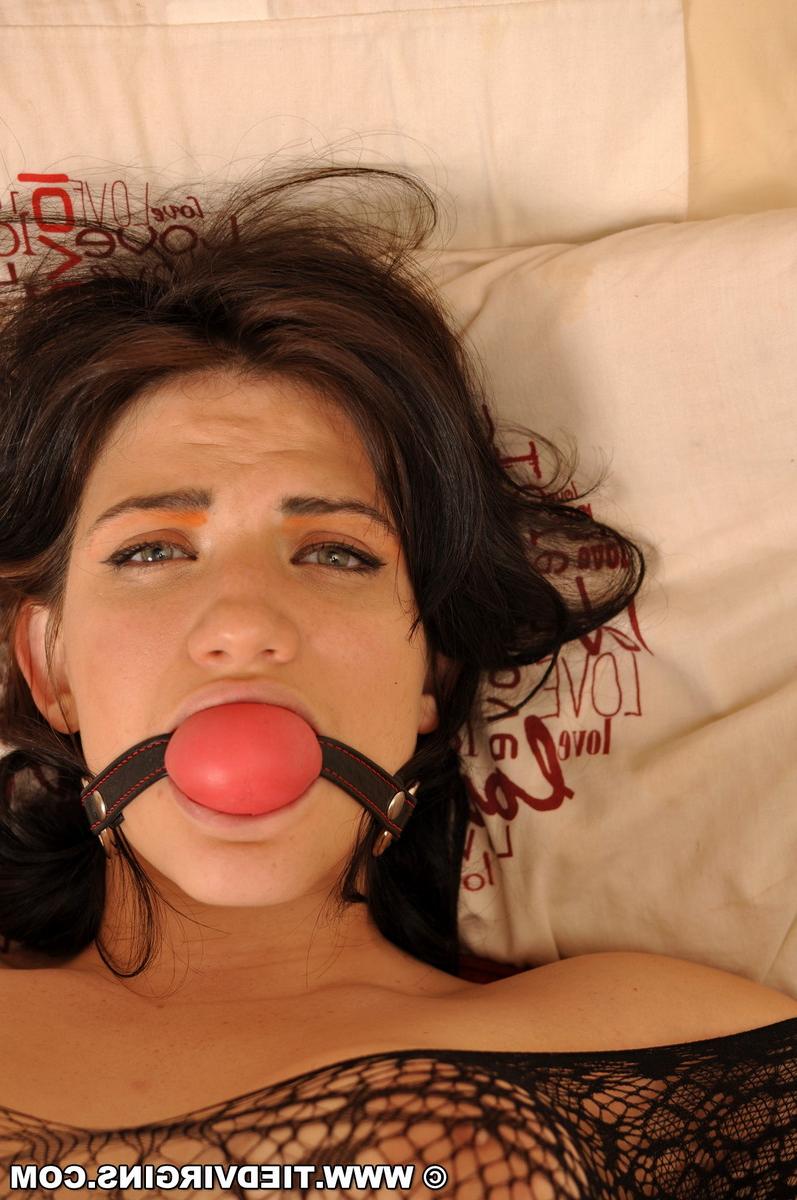12P Une fille chaude est attachée à un lit avec un bâillon-boule fermement fixé dans sa bouche.