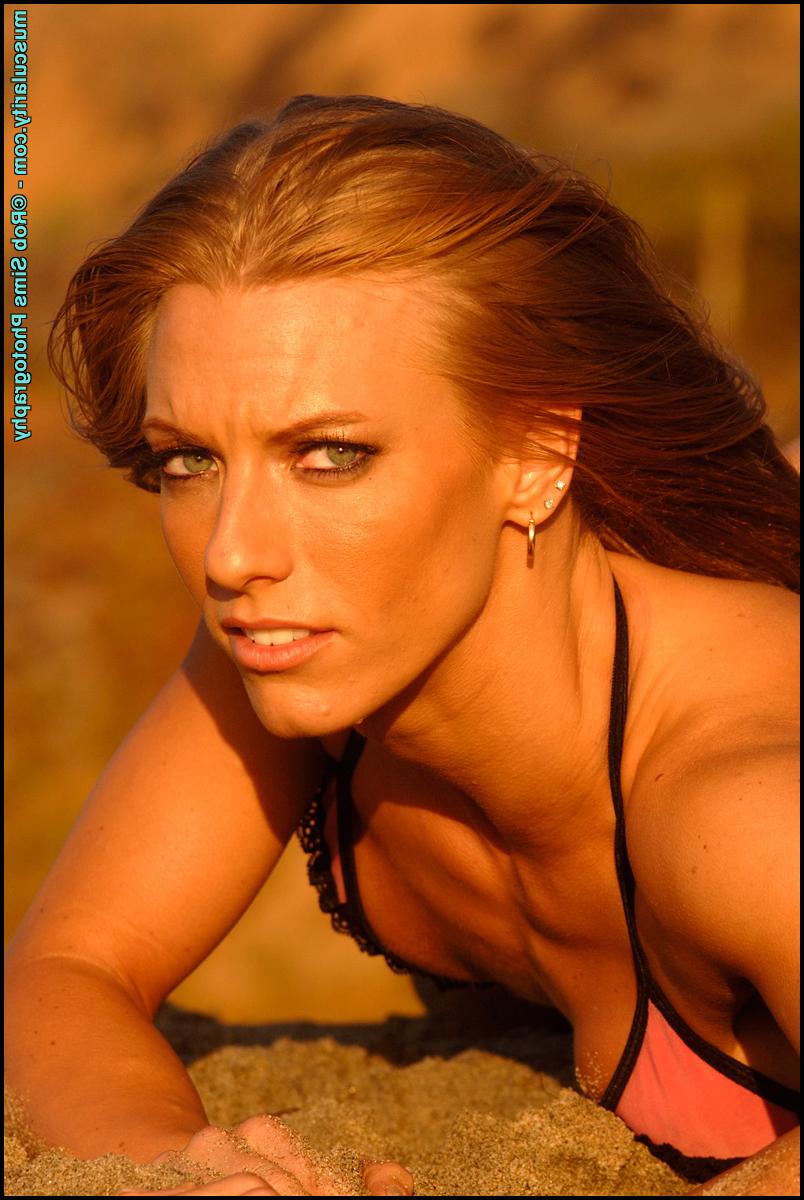 15P Bodybuilder Courtney Schwartzmeyer poses on a beach in a bikini