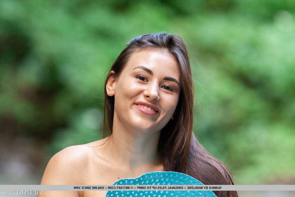 18P A linda adolescente morena Sumiko posa nua em um riacho raso com um chapéu de sol