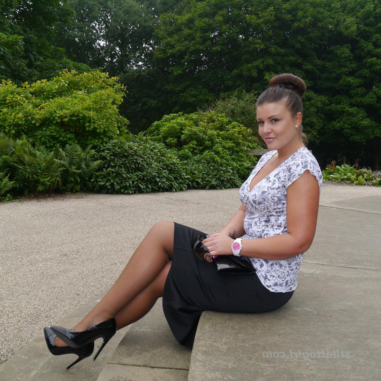 16P Die gekleidete Frau Karen zeigt ihre neuen Stilettos in einem Park