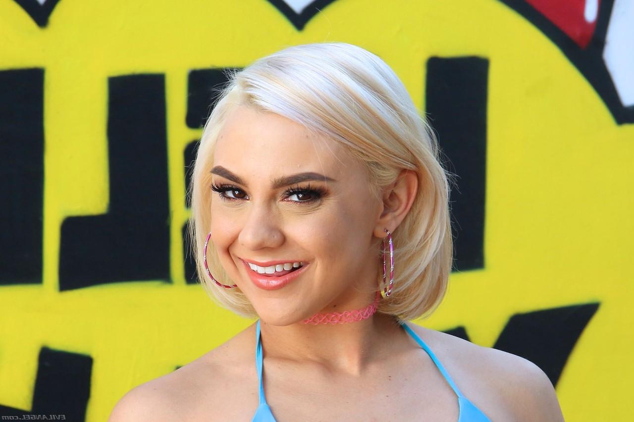 18P La blonde platine Maria Jade fait le grand écart avec sa chatte nue sur un canapé blanc.
