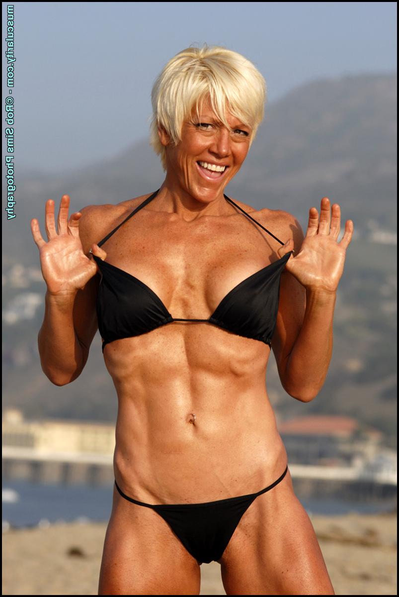 15P Older blonde bodybuilder Chloe Craig frees her tits from a bikini at the beach