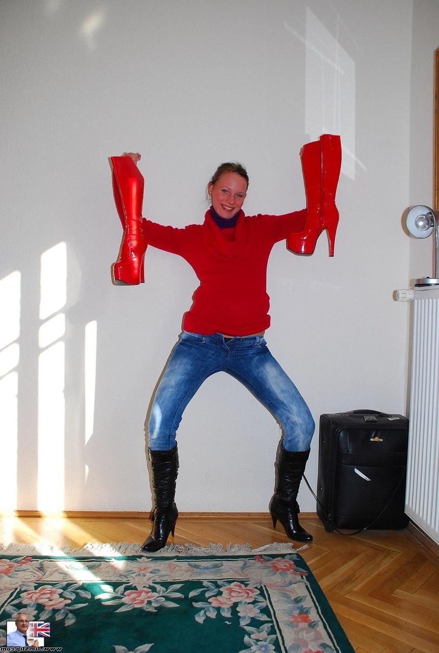 18P Gita Blonde, jeune à queue de cochon, pose en bas rouges et en bottes hautes.