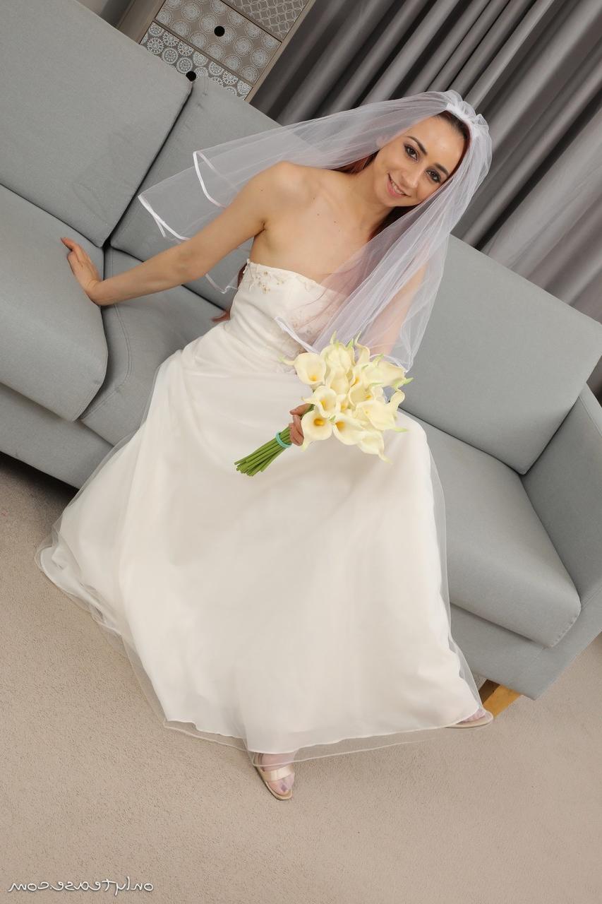 16P La mariée rousse Tania Aresti se met nue avec un voile, des jarretières et des bas de nylon.