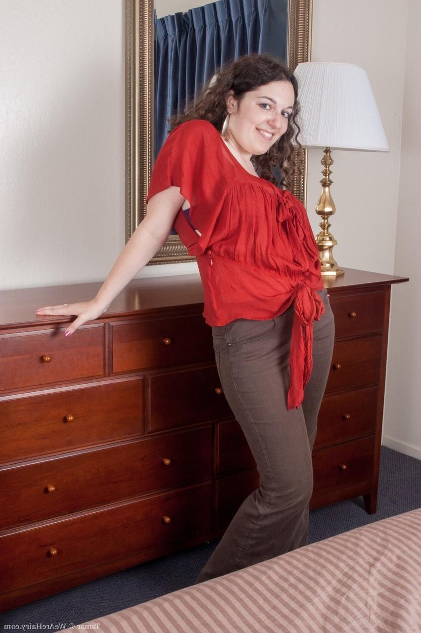 11P La brune BBW Tamar présente son buisson en chaussettes sur une commode.