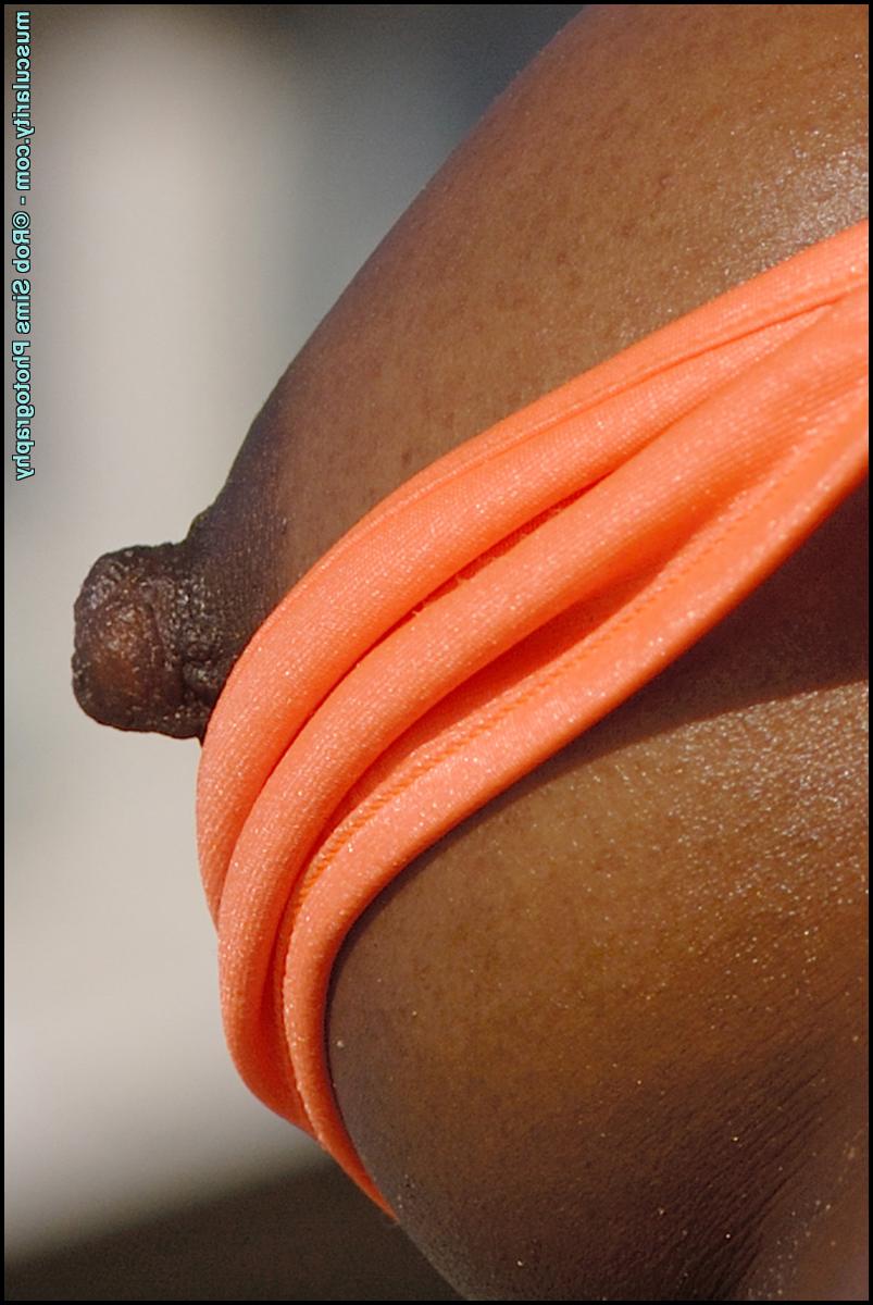 15P Ebony bodybuilder Victoria Dominguez lets her tits free of a bikini on a beach