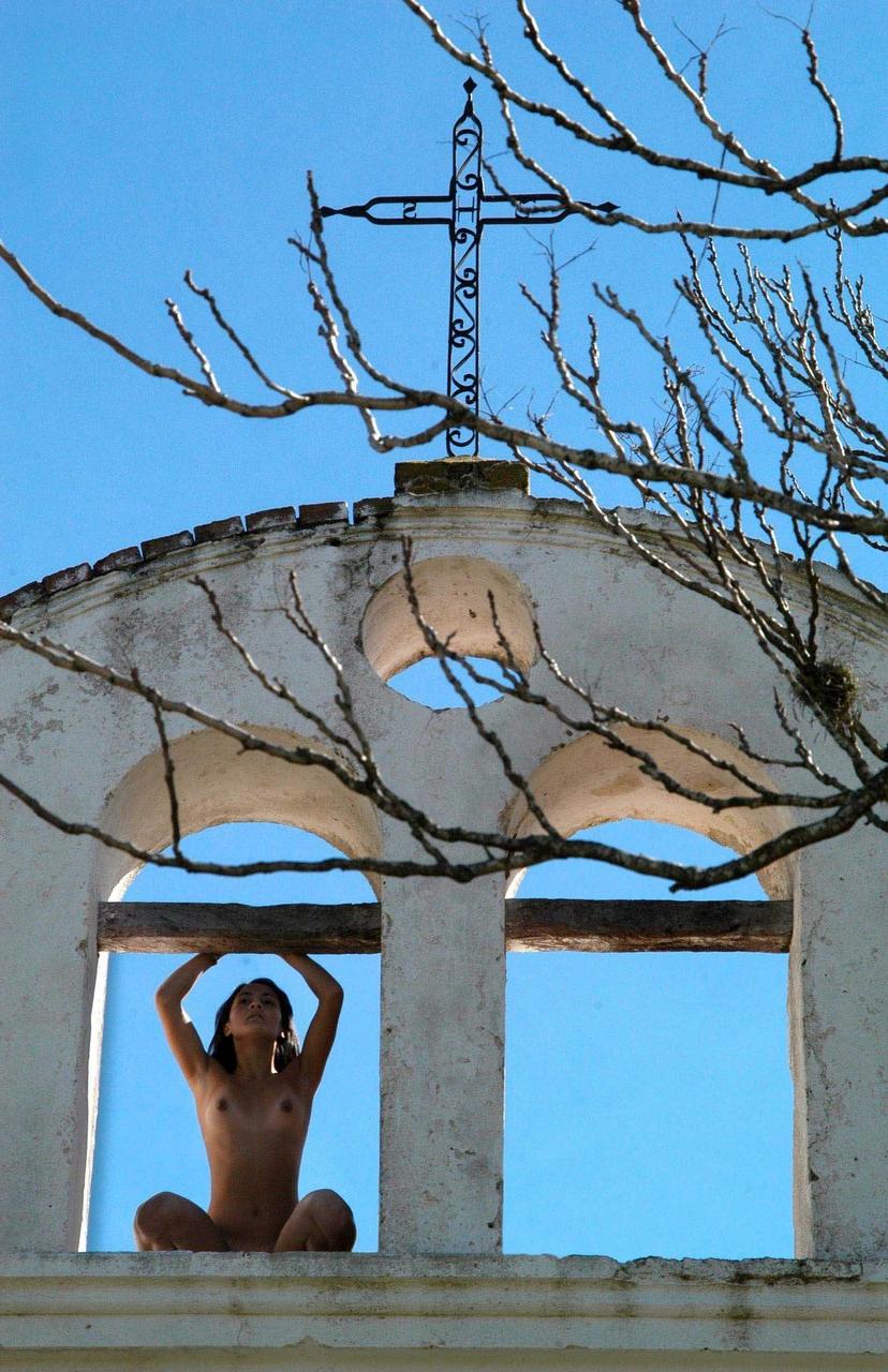 18P Une beauté aux pieds nus avec un cul à tomber par terre s'allonge nue sur une balustrade en pierre.