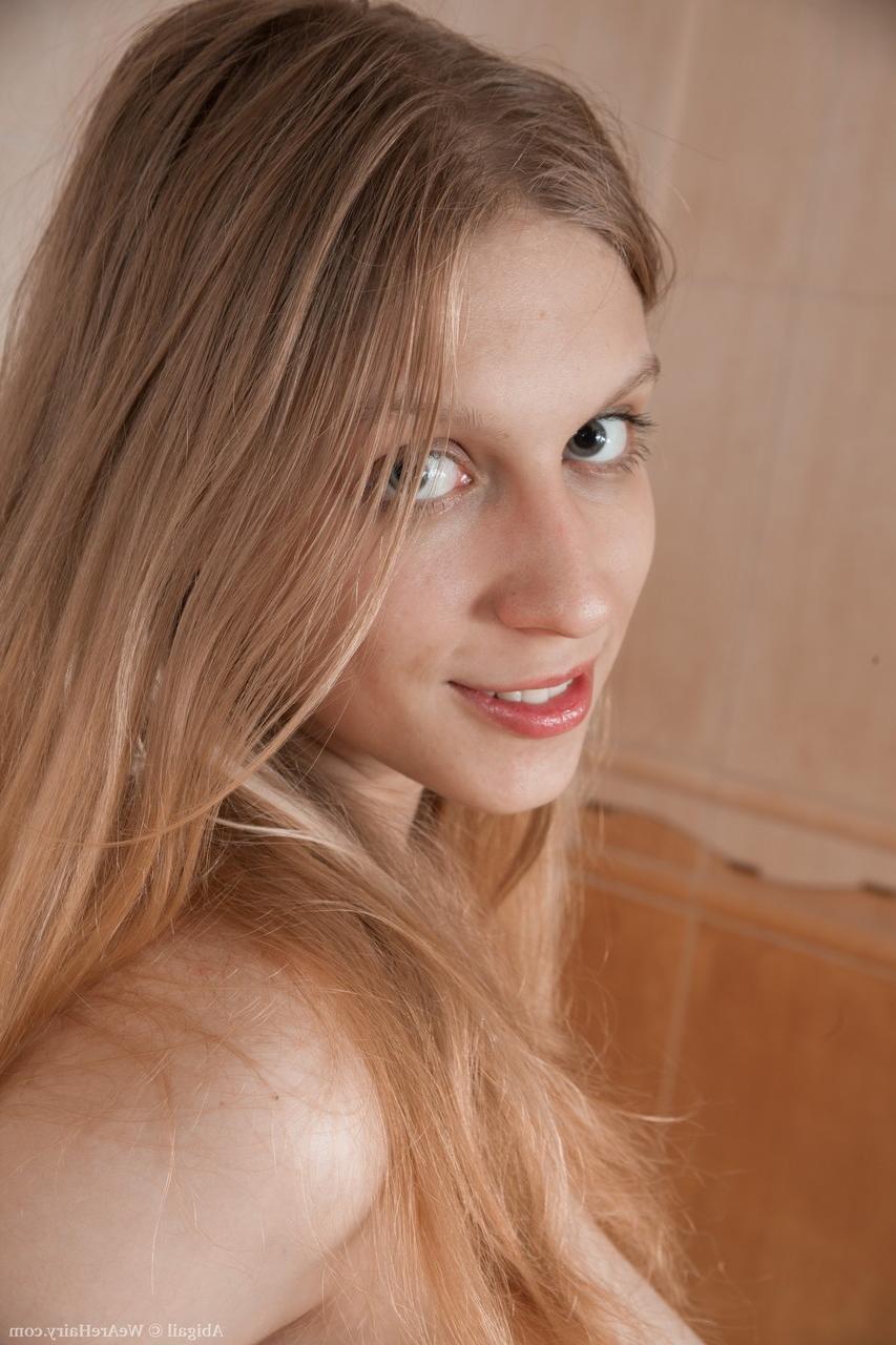 16P Abigail, jeune blonde aux petites fesses, se déshabille et touche sa palourde poilue.