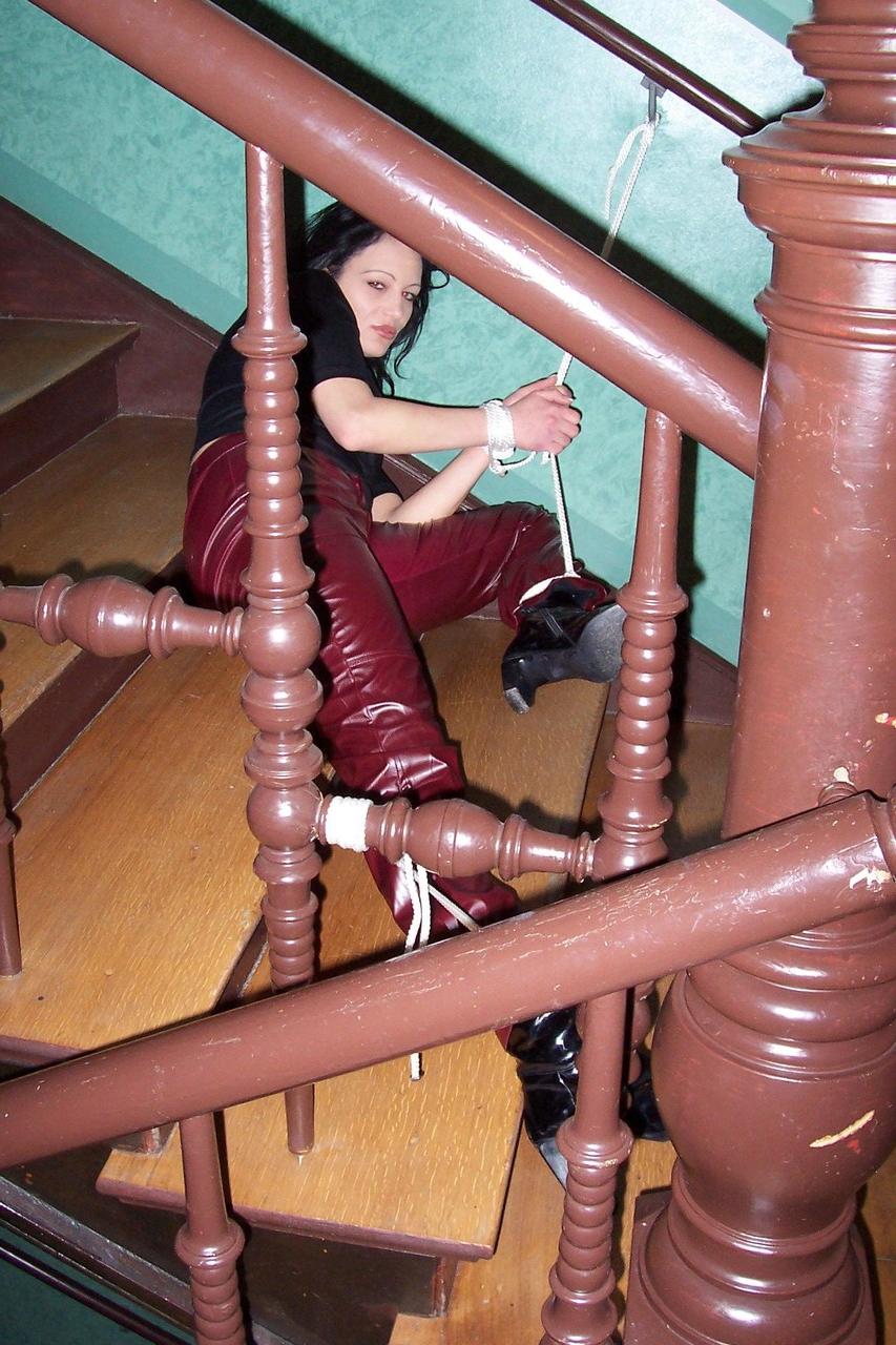 16P Brunette chick finds herself gagged and bound in leather pants on the stairs