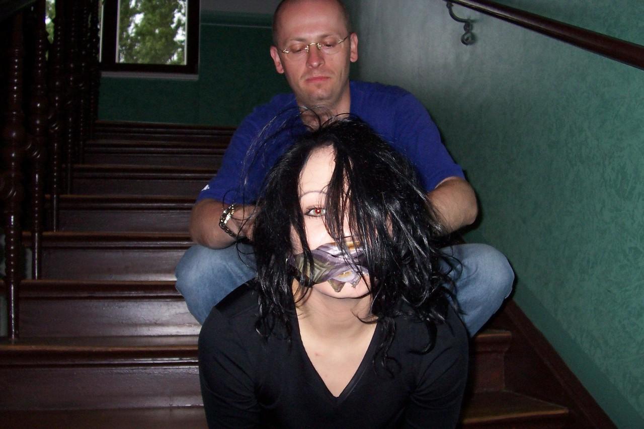 16P Brunette chick finds herself gagged and bound in leather pants on the stairs