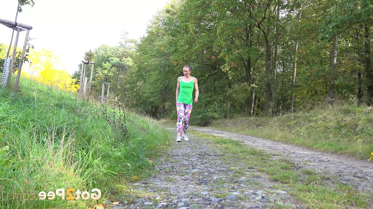 15P A mulher europeia Valentina Ross se agacha para fazer xixi enquanto caminha por uma estrada rural