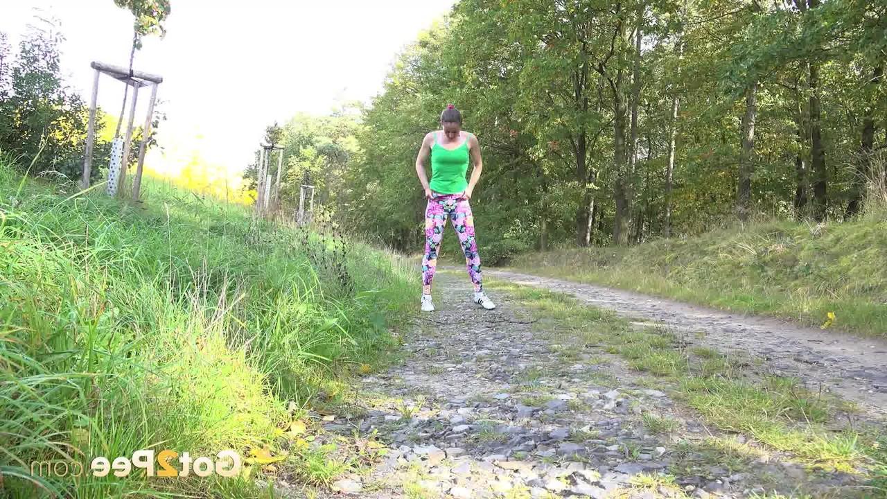 15P A mulher europeia Valentina Ross se agacha para fazer xixi enquanto caminha por uma estrada rural