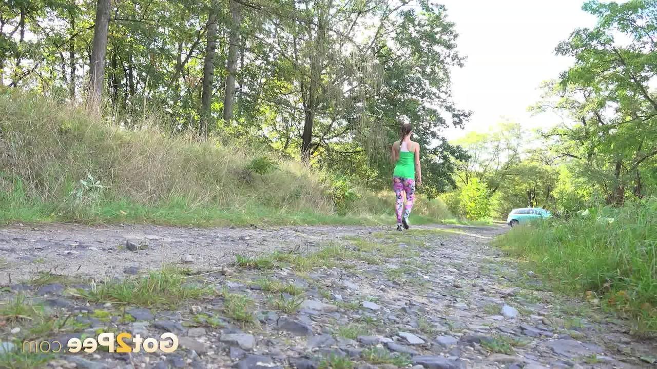 15P A mulher europeia Valentina Ross se agacha para fazer xixi enquanto caminha por uma estrada rural