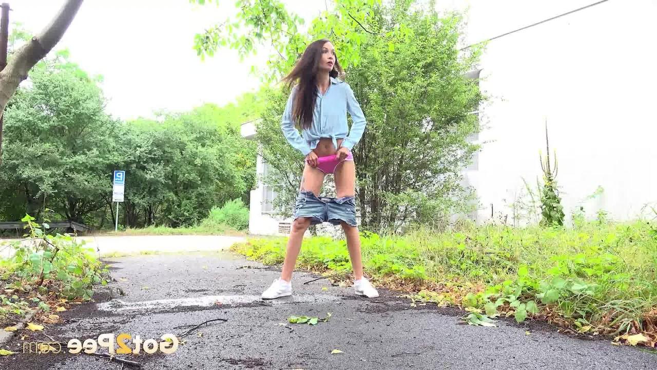 15P Skinny girl Mistica gets caught taking a piss on a paved path