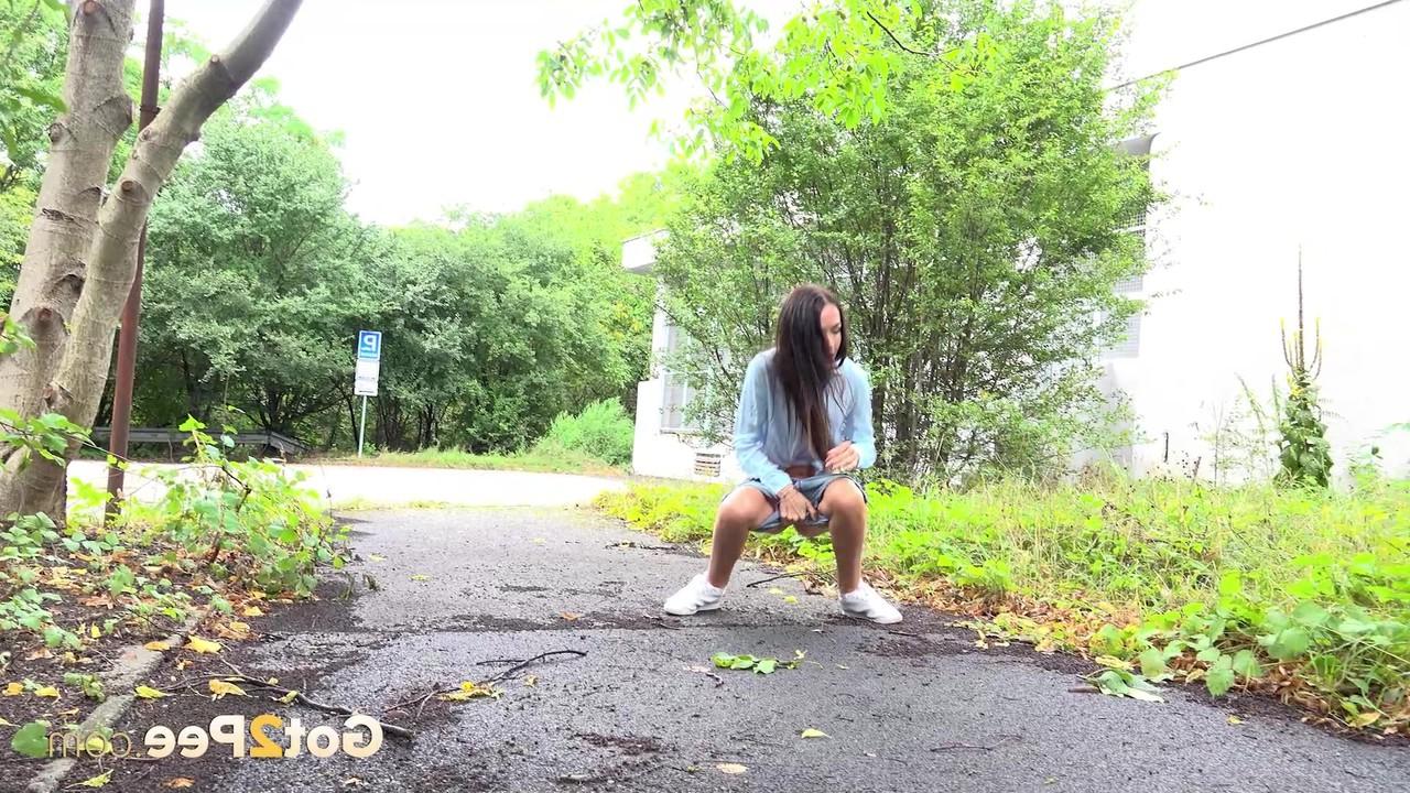 15P Skinny girl Mistica gets caught taking a piss on a paved path