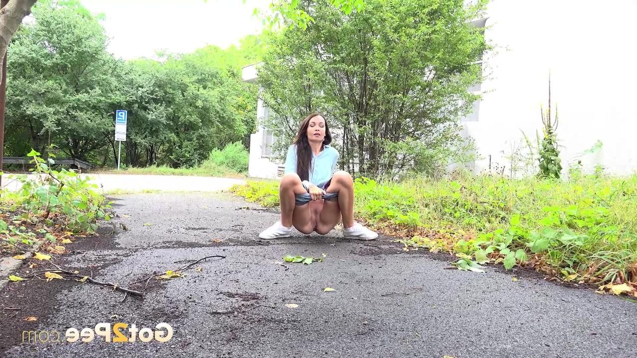 15P Skinny girl Mistica gets caught taking a piss on a paved path
