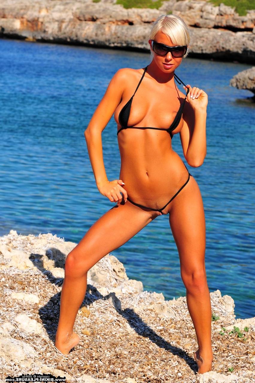 16P Natali Blond, une blonde platine, enlève un micro bikini près de l'eau libre.