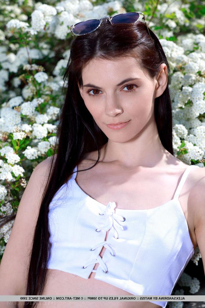 18P La joven morena aleksandrina se desnuda totalmente delante de unos arbustos en flor