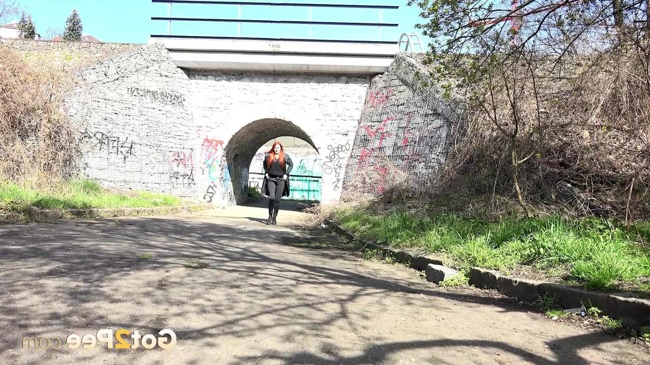 15P La joven pelirroja Katy Rose orina en una carretera pavimentada durante el día