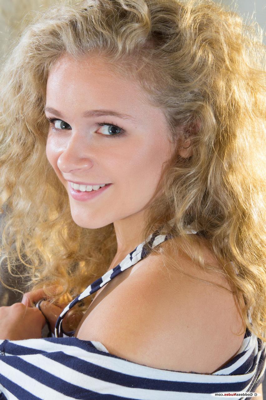 20P Curly-haired babe Mikana strips down naked and poses on the sofa