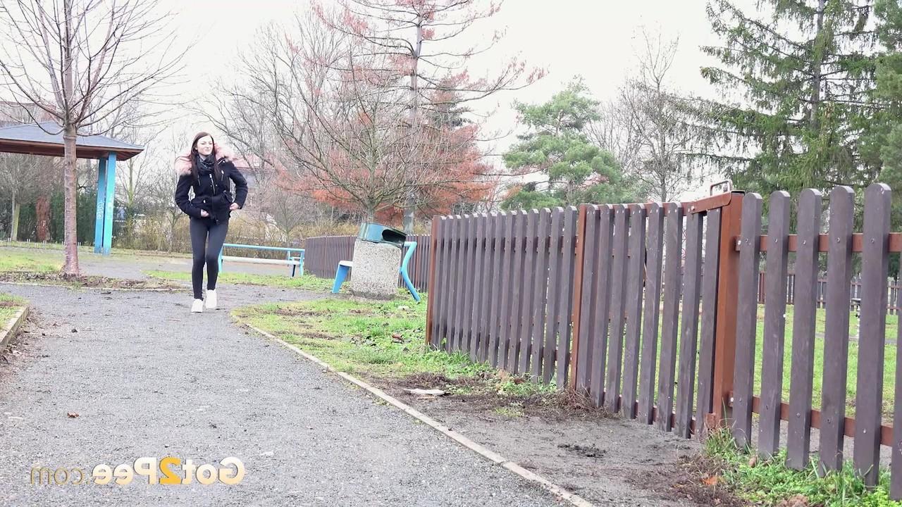 15P Caucasian girl Katy Sky ducks behind a picket fence for a badly needed pee