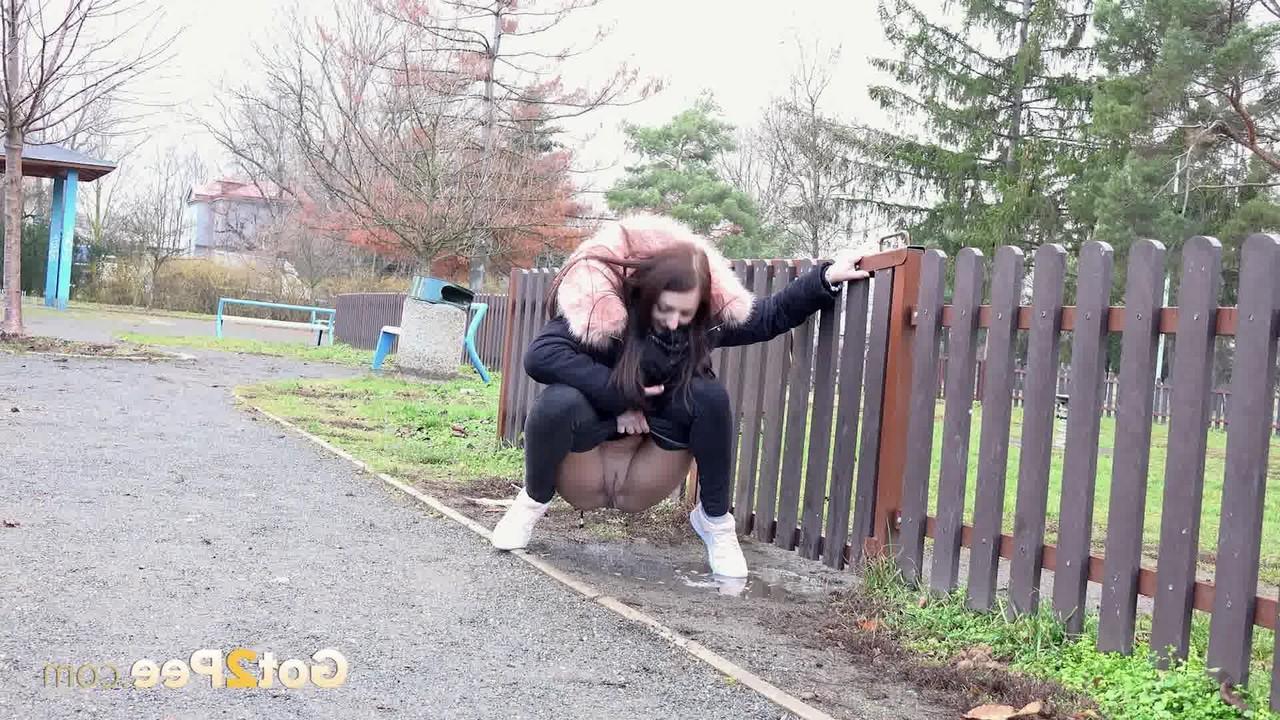 15P Caucasian girl Katy Sky ducks behind a picket fence for a badly needed pee