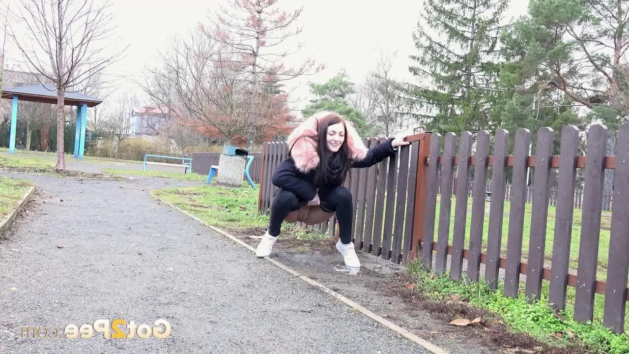 15P Caucasian girl Katy Sky ducks behind a picket fence for a badly needed pee
