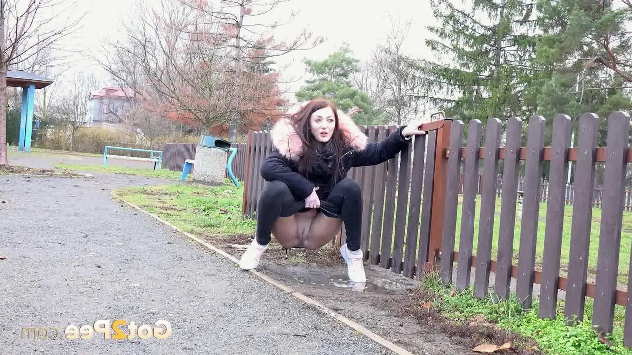 15P Caucasian girl Katy Sky ducks behind a picket fence for a badly needed pee
