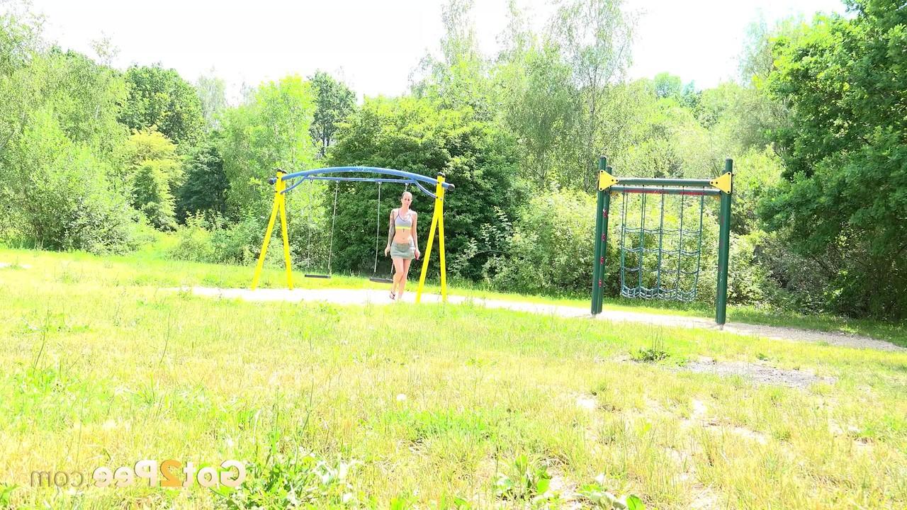 15P Das langbeinige Mädchen Ali Bordeaux pisst auf eine Bank in einem öffentlichen Park