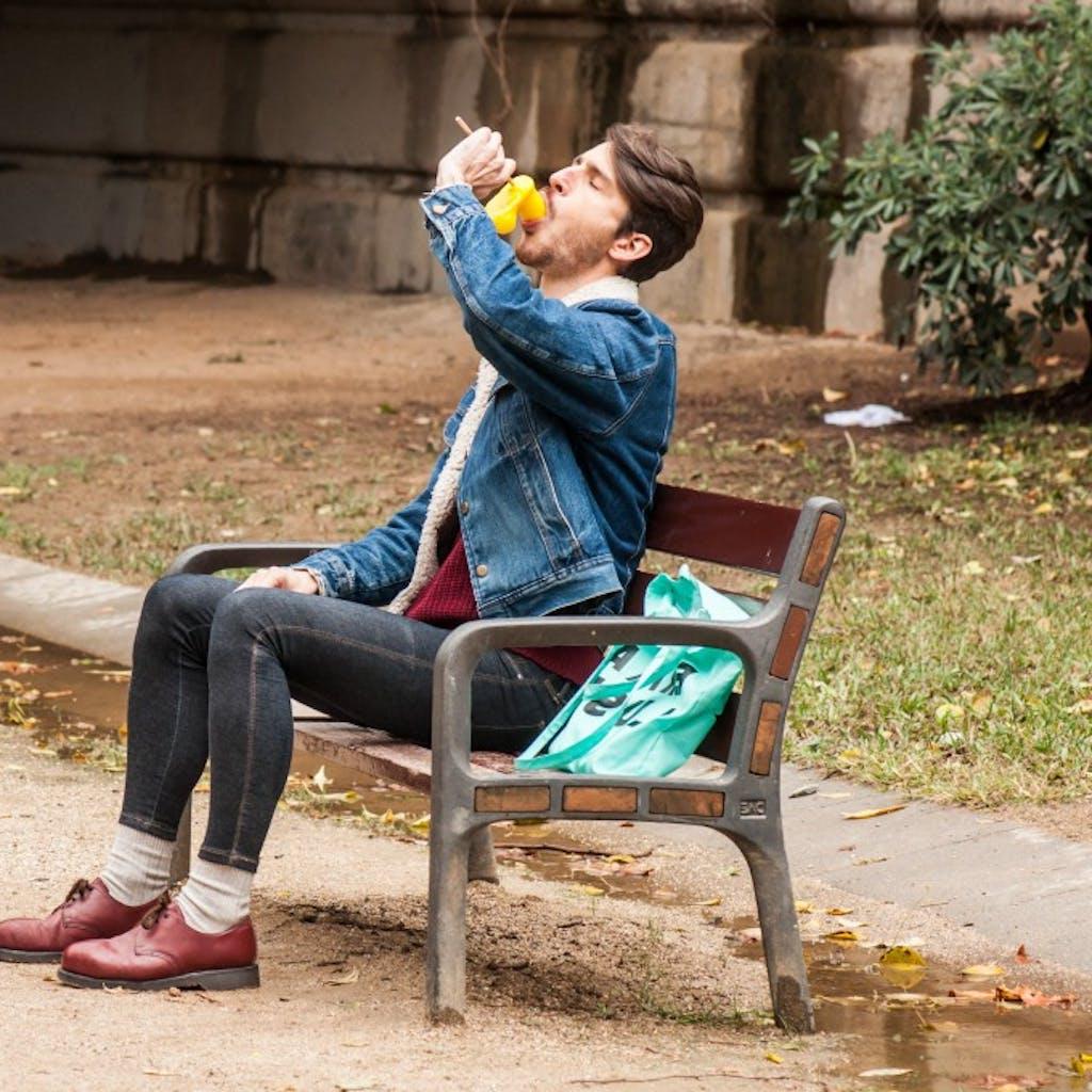 12P Gay brunette Victor A erotically sucks a sex toy lollipop on a public bench