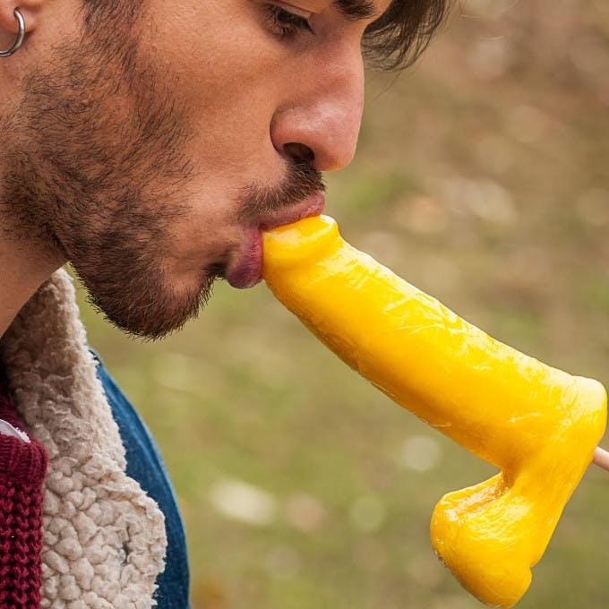 12P Gay brunette Victor A erotically sucks a sex toy lollipop on a public bench