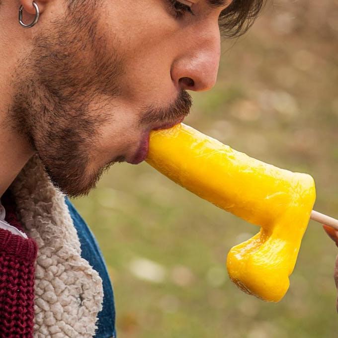 12P Gay brunette Victor A erotically sucks a sex toy lollipop on a public bench