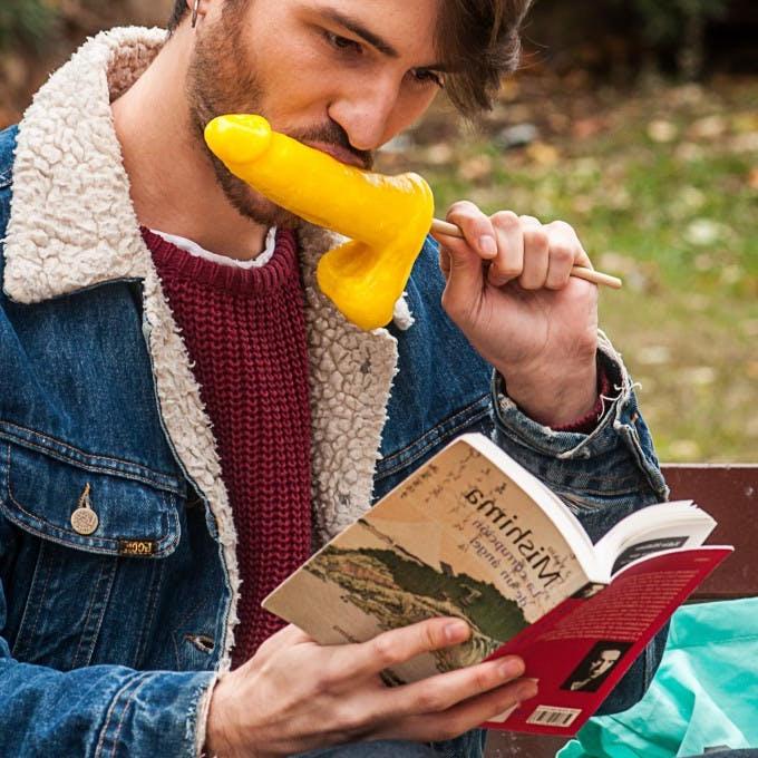 12P Gay brunette Victor A erotically sucks a sex toy lollipop on a public bench