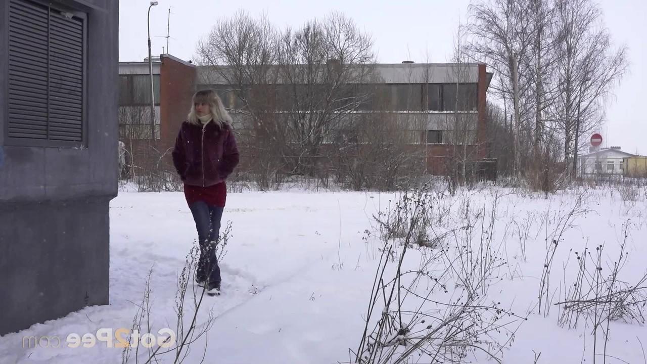 15P La chica caucásica Jessy muestra su culo desnudo mientras orina en el suelo cubierto de nieve.