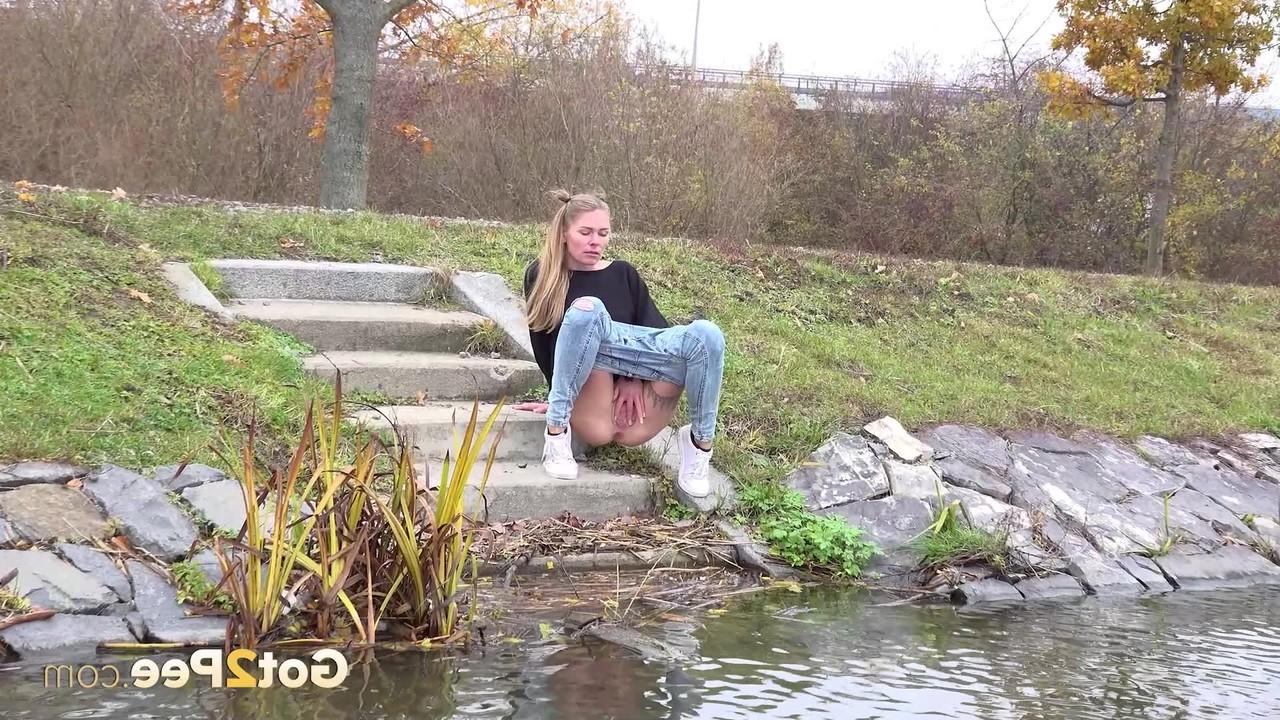 15P Claudia Macc desce degraus de concreto para mijar na água