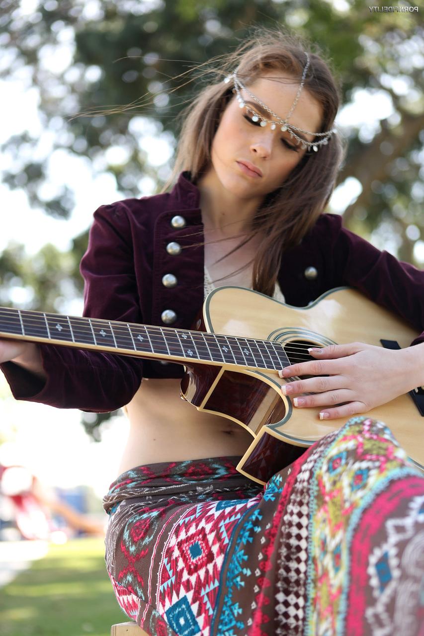 17P L'esprit libre britannique Penny Brooks exhibe ses seins en jouant de sa guitare