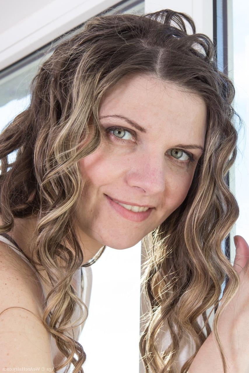 15P Fille solo aux cheveux bouclés expose sa chatte très poilue et ses petits seins