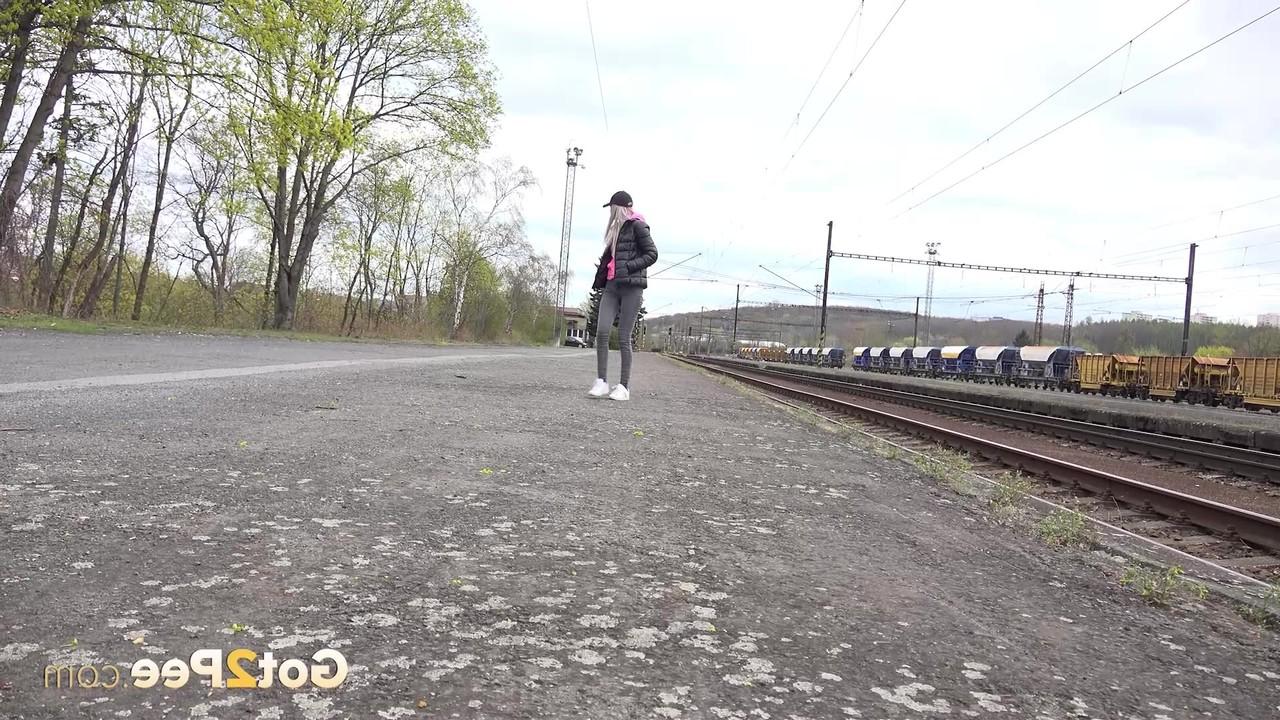 15P A loira Mistica abaixa as calças jeans pretas para fazer xixi ao lado dos trilhos do trem