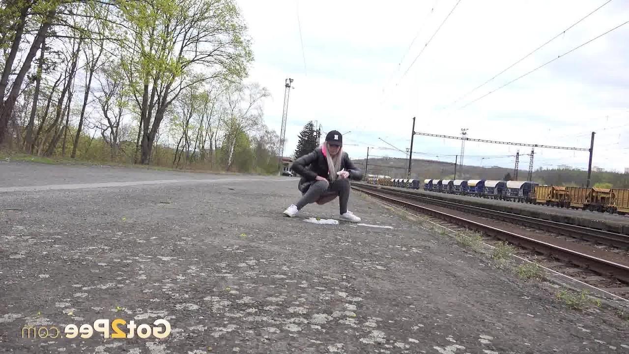 15P A loira Mistica abaixa as calças jeans pretas para fazer xixi ao lado dos trilhos do trem