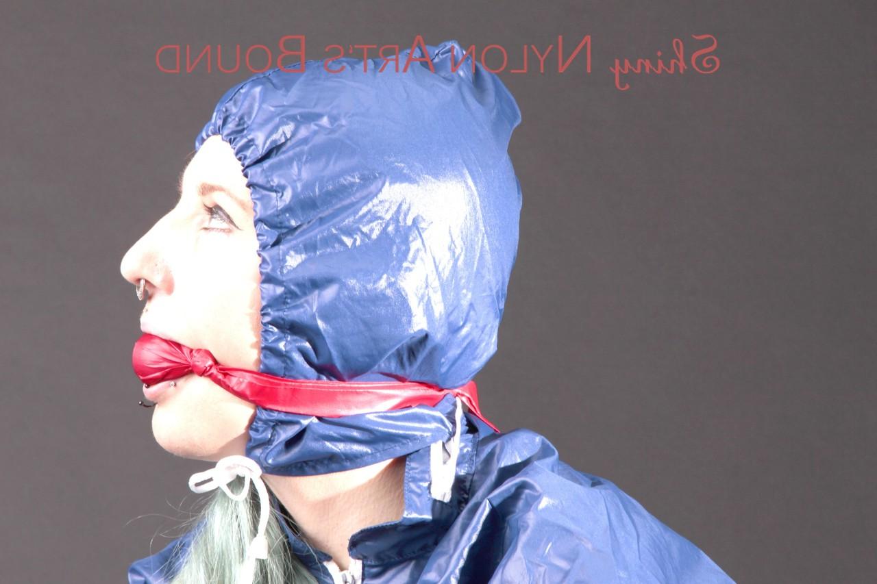 16P Caucasian female is restrained and gagged in a raincoat and rubber boots