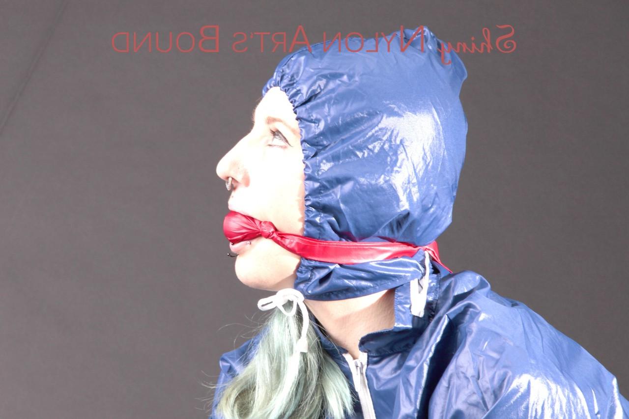 16P Caucasian female is restrained and gagged in a raincoat and rubber boots