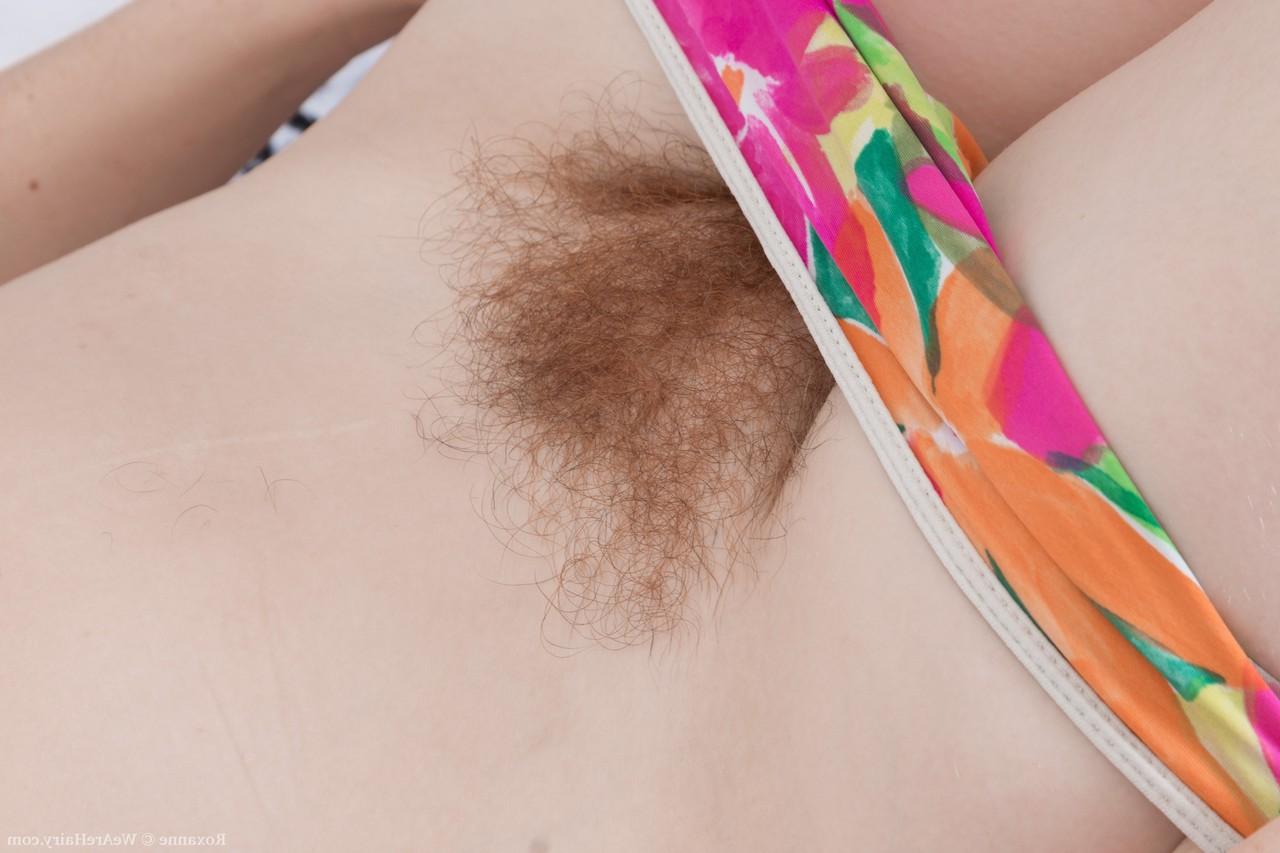 20P La brune amateur Roxanne révèle sa chatte poilue et l'étire à l'extérieur.