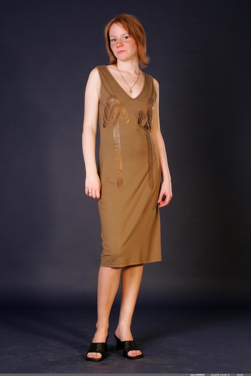 20P La jeune glamour Anne enlève ses vêtements et pose nue et pieds nus.