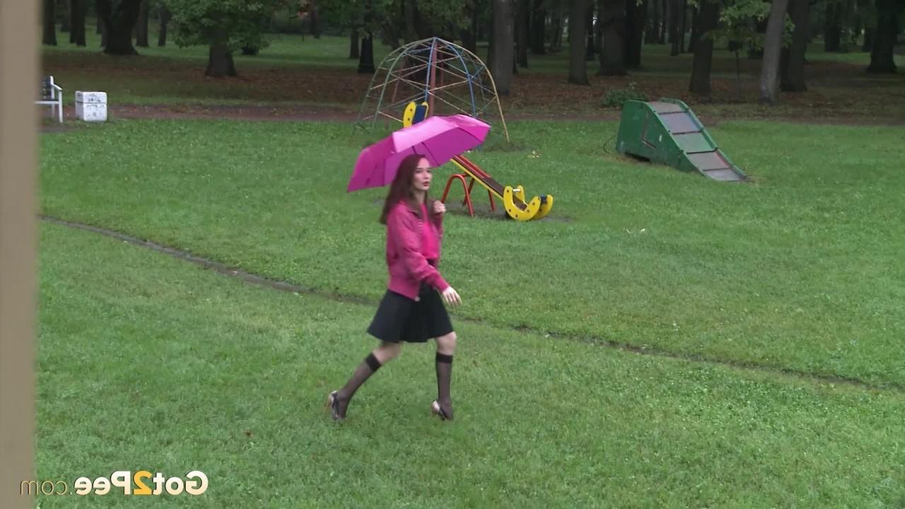 15P A simpática garota Oksana se agacha para mijar no equipamento do playground em um parque público