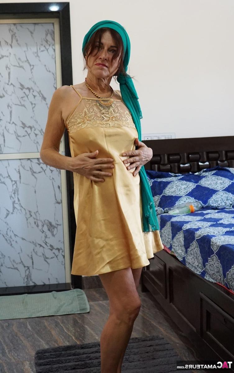 16P Die ältere Brünette Diana Ananta spielt mit ihrem Busch auf einem Bett