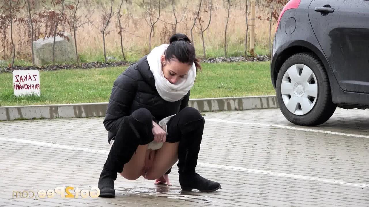 15P A garota sozinha Eveline Neill se agacha para mijar em um estacionamento com roupas de inverno