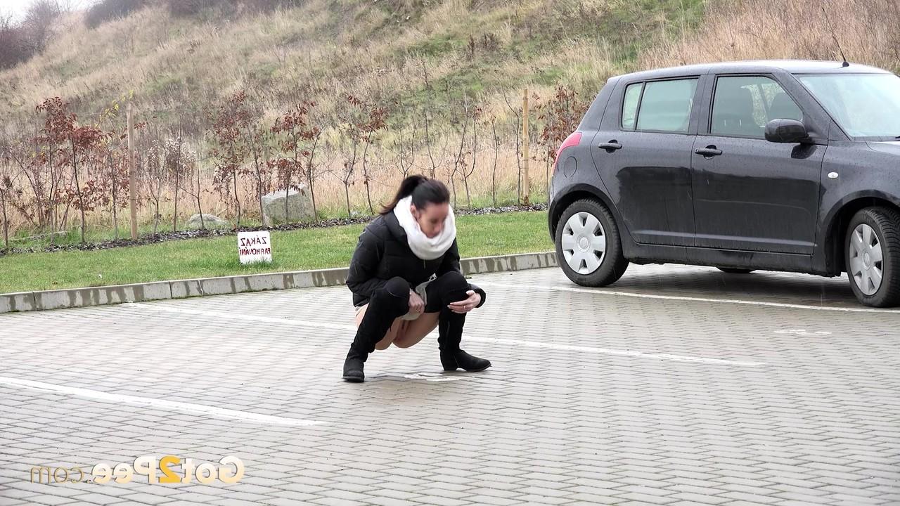 15P A garota sozinha Eveline Neill se agacha para mijar em um estacionamento com roupas de inverno